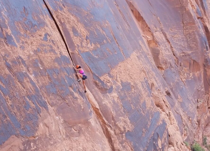 Female climber ascending a crack during an all-women climbing camp in Moab.