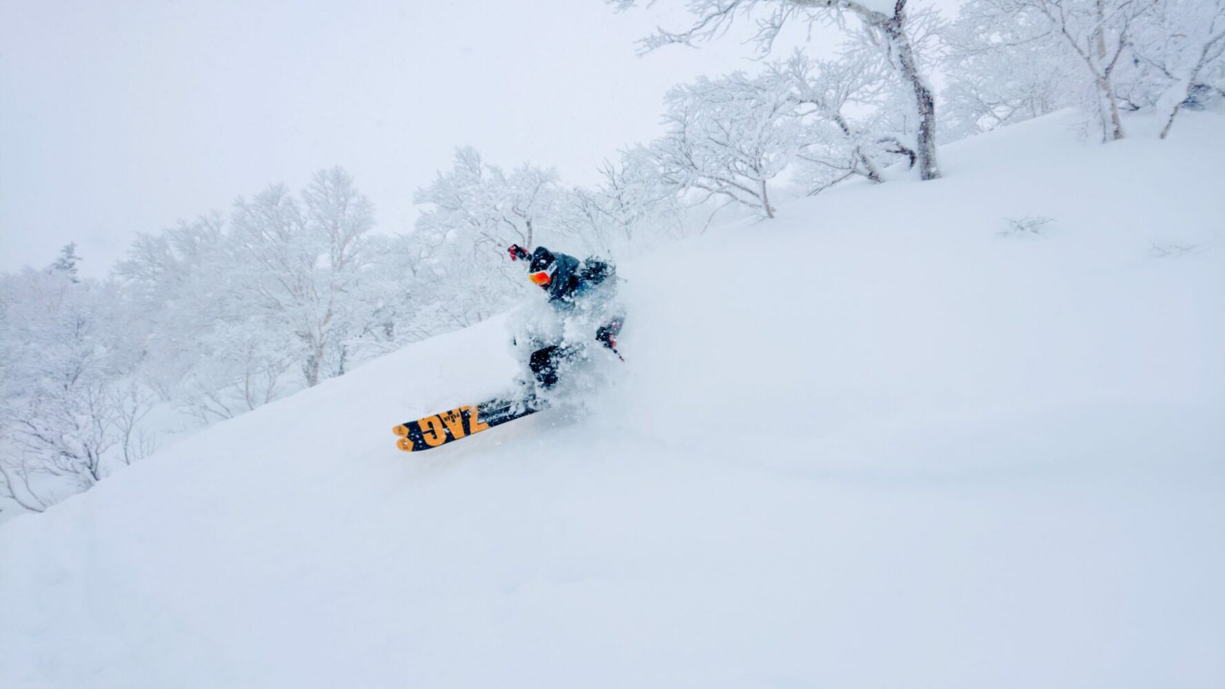 A skier jumping in powdery snow.