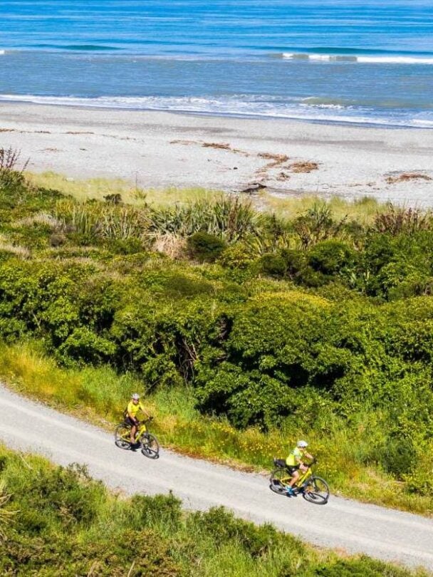 Cyclists on a path which is part of the iconic West Coast Wilderness Trail on the South Island in New Zealand