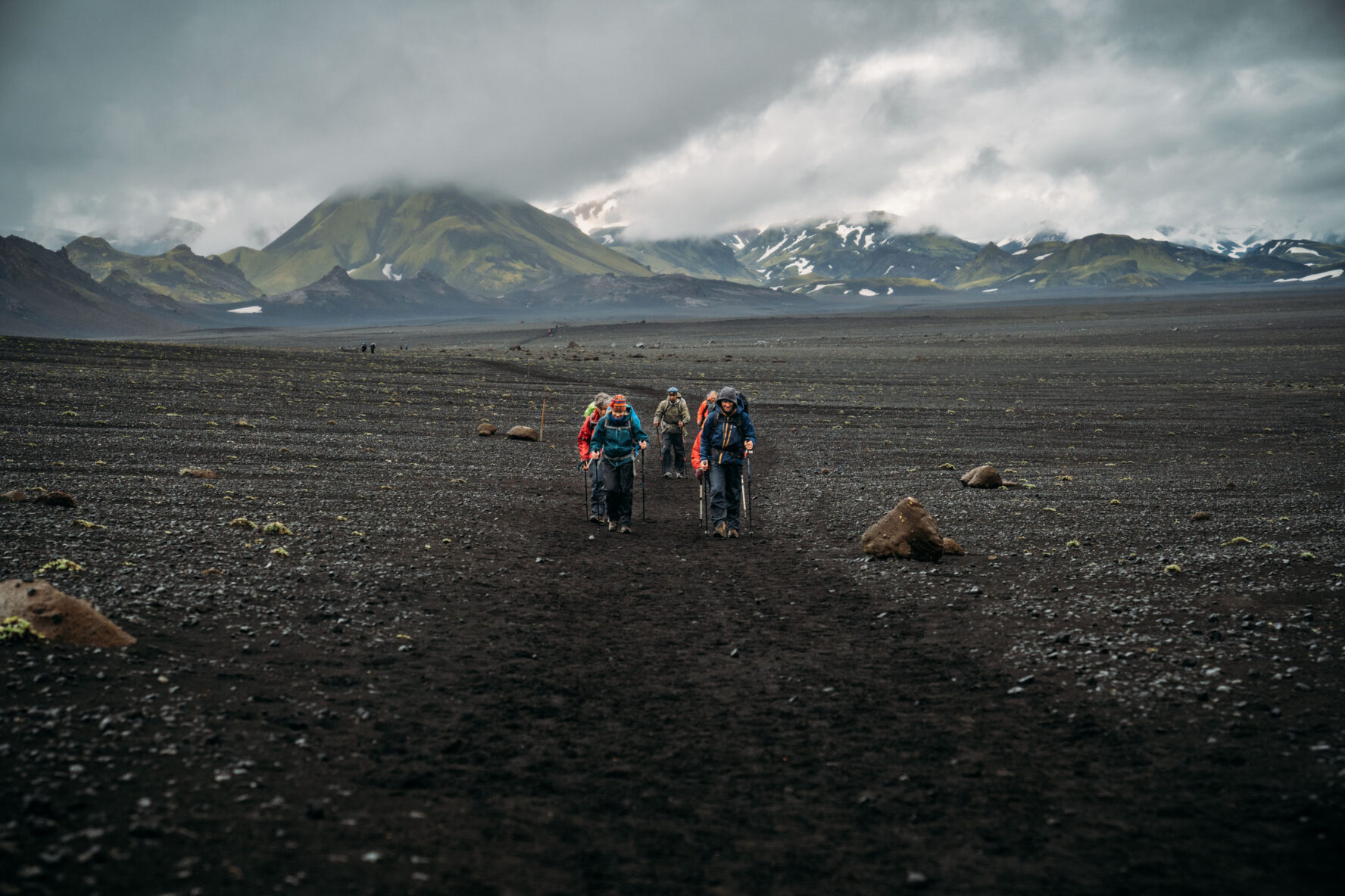 Hikers on black soil in Iceland