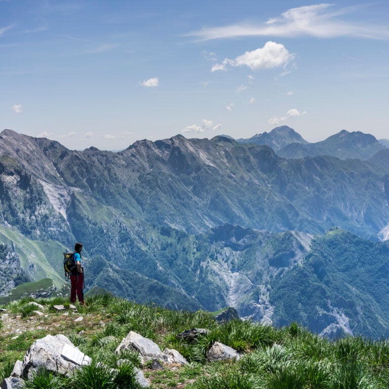A hiker enjoying views while hiking in the mountains of Tuscany.