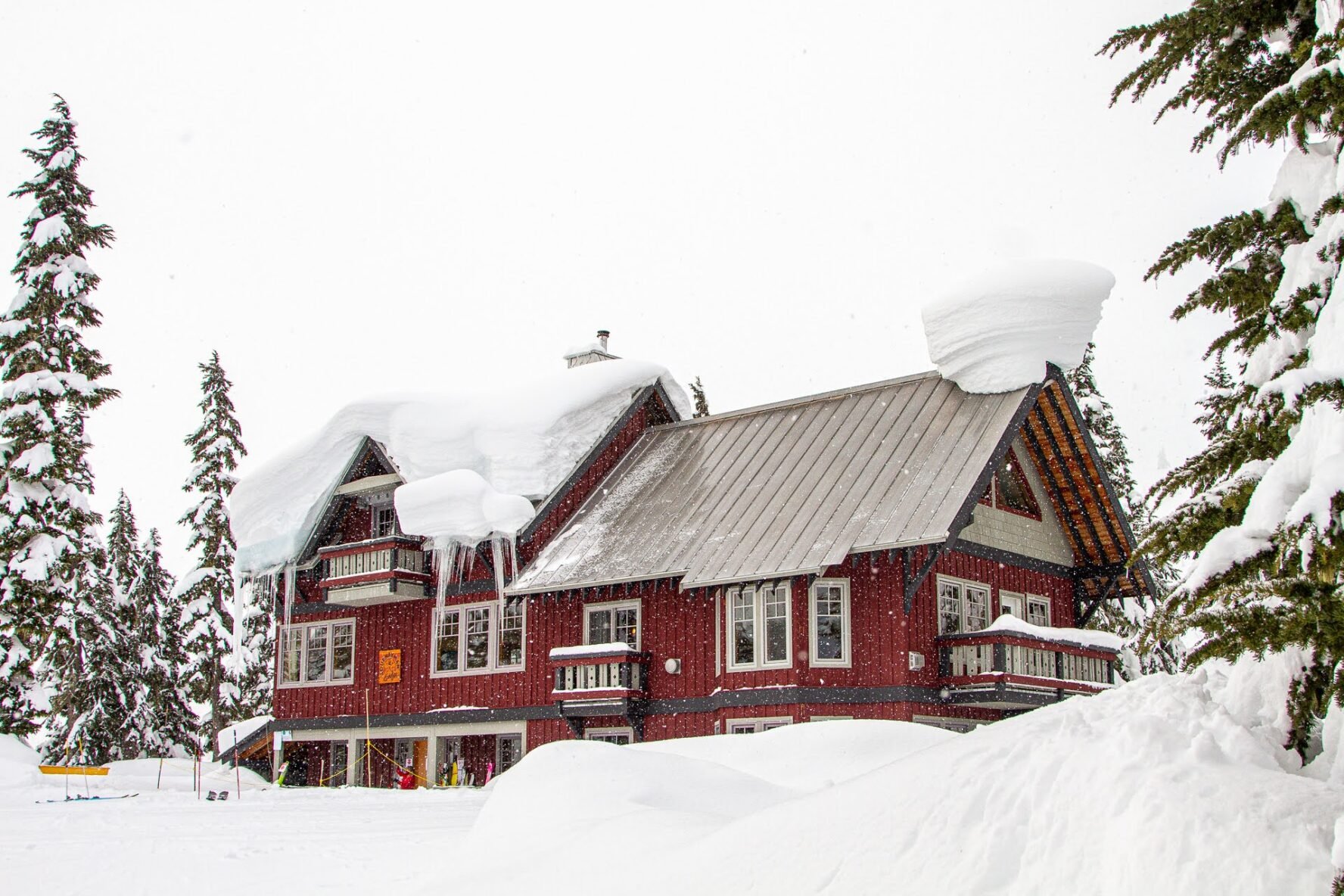 The Journeyman lodge which is red pictured on a snowy day with snow all over the rooftop.