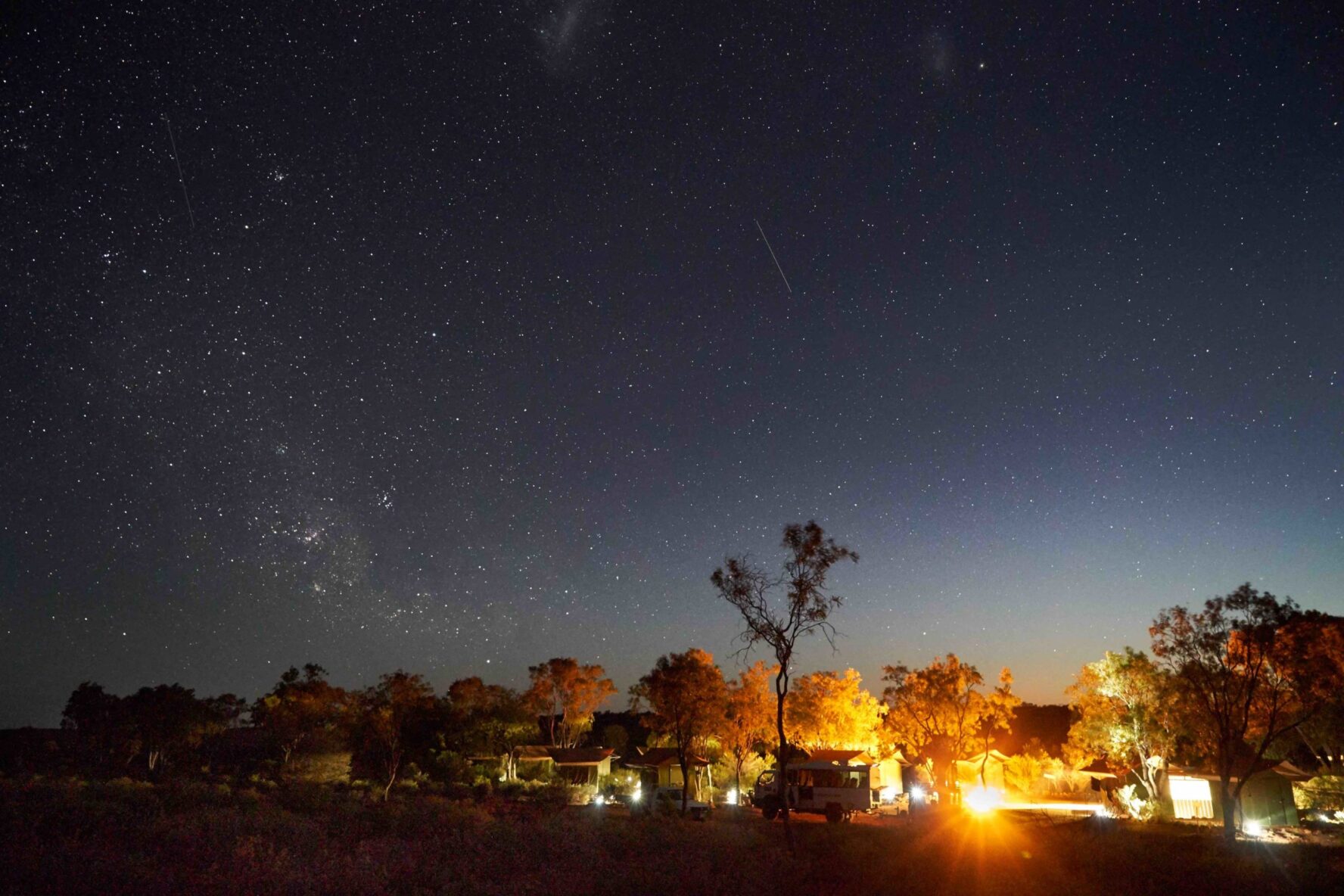 A campsite along the Larapinta Trail seen during night with a starlit sky as the backdrop.