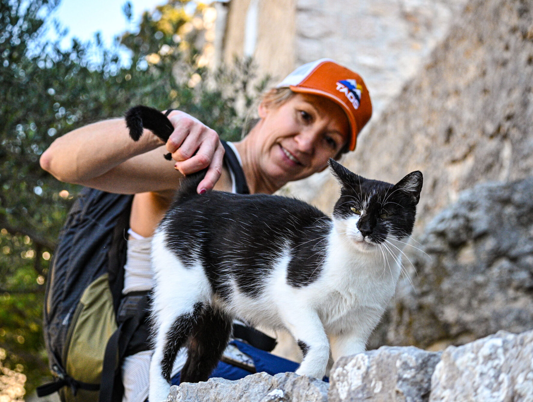 Hiker petting a cat on an island