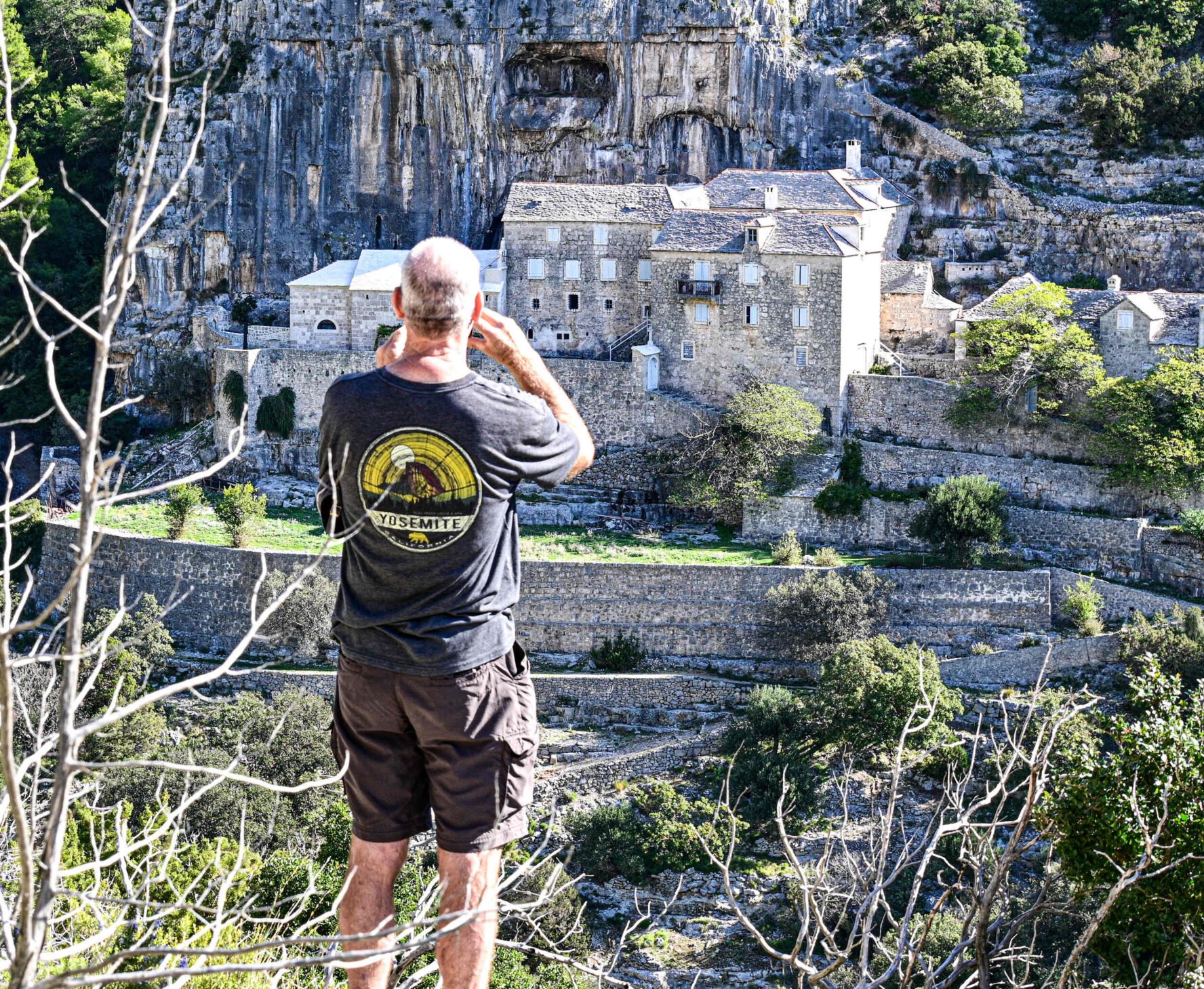 Hiker photographing the Blaca monastery on the island of Brač