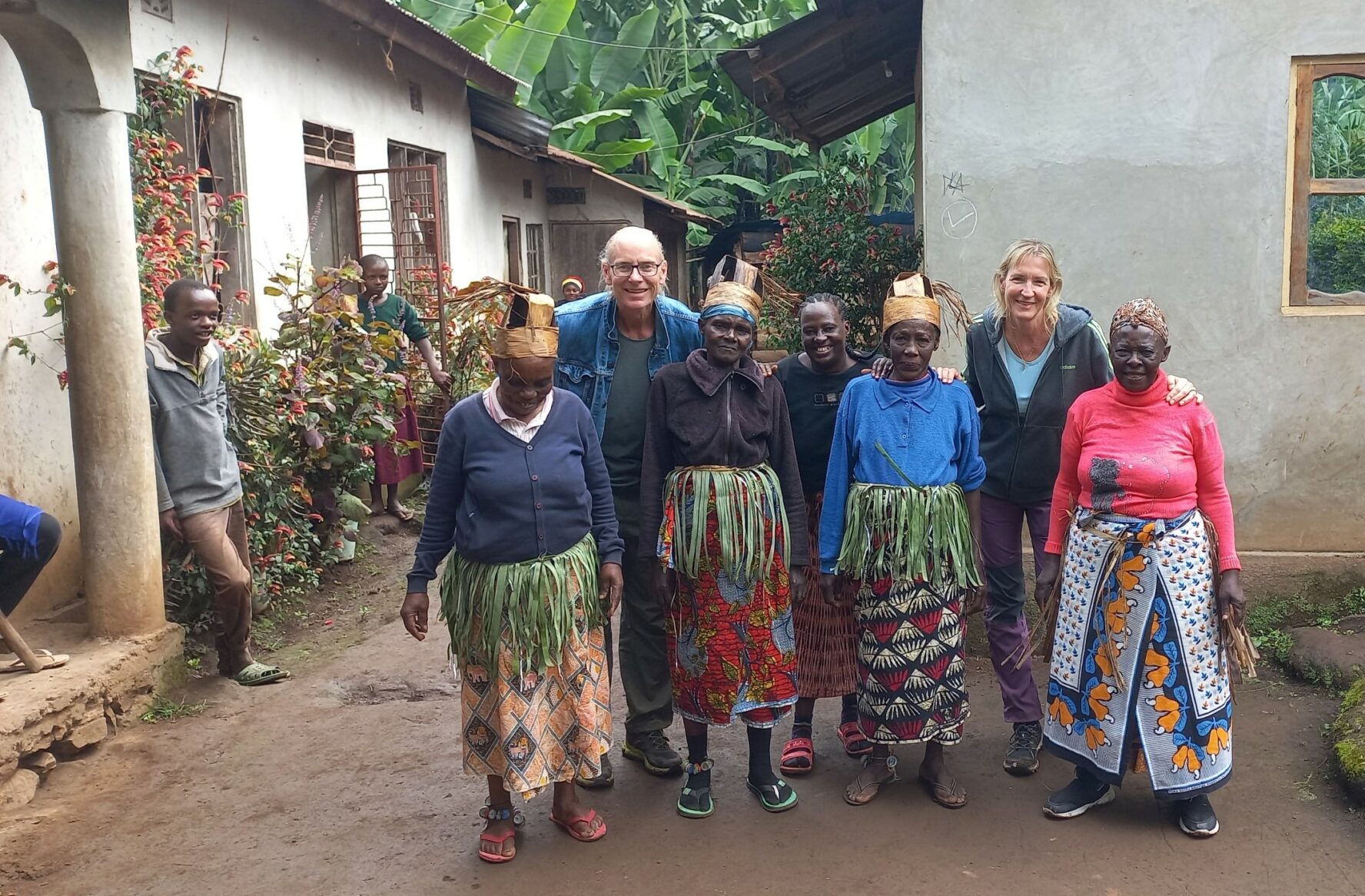 Trekkers taking a picture with people from the Chagga tribe wearing their folk costumes during a cultural tour.