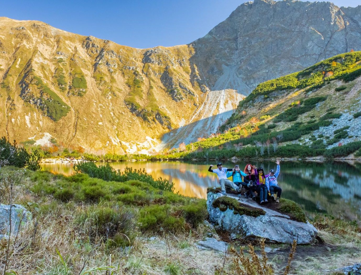 Hikers posing beside a glacial lake in the Tatras, Slovakia.