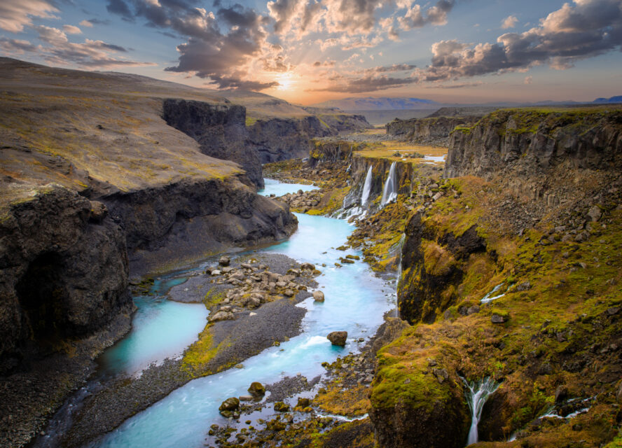 Scenic landscape view of incredible Sigoldugljufur canyon in highlands with turquoise river and sunset, Iceland. Volcanic landscape on background. Popular tourist attraction.