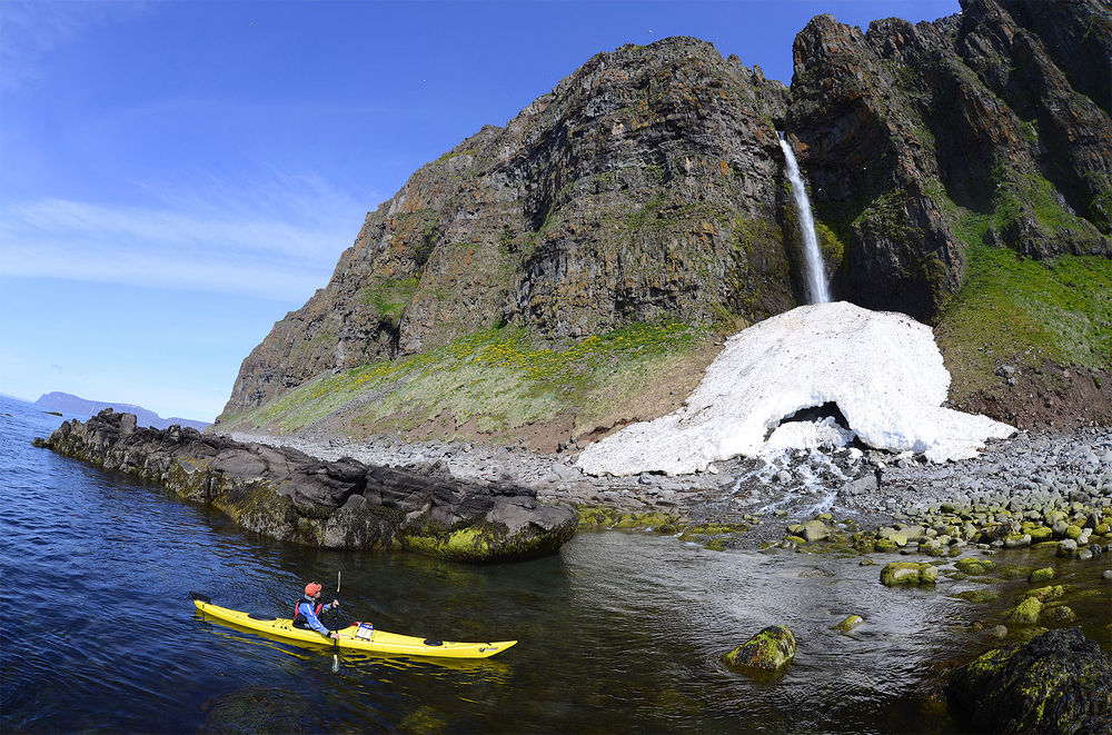 Kayaks under waterfall in Iceland