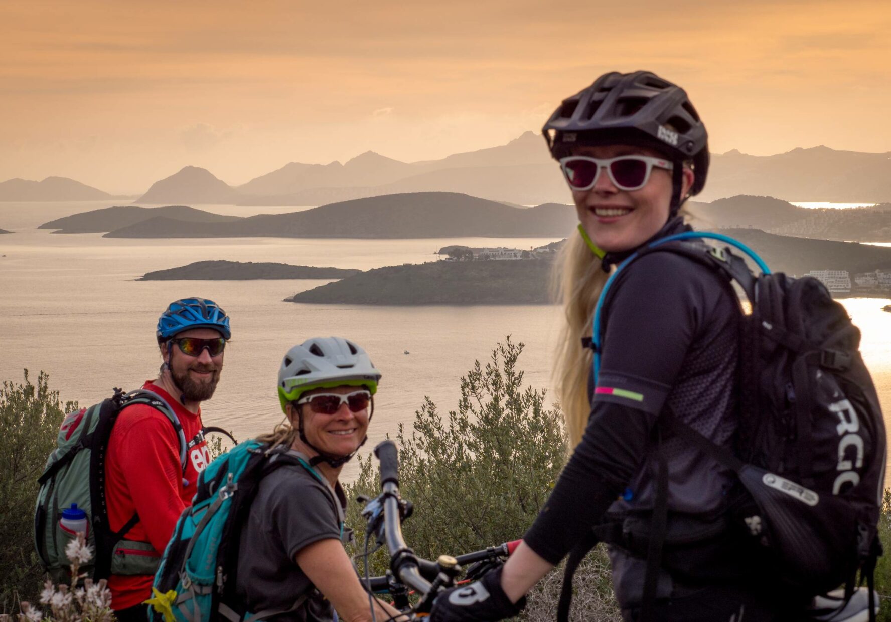 MTBers enjoying sunset and the view of small islands in the South Greek Aegean.