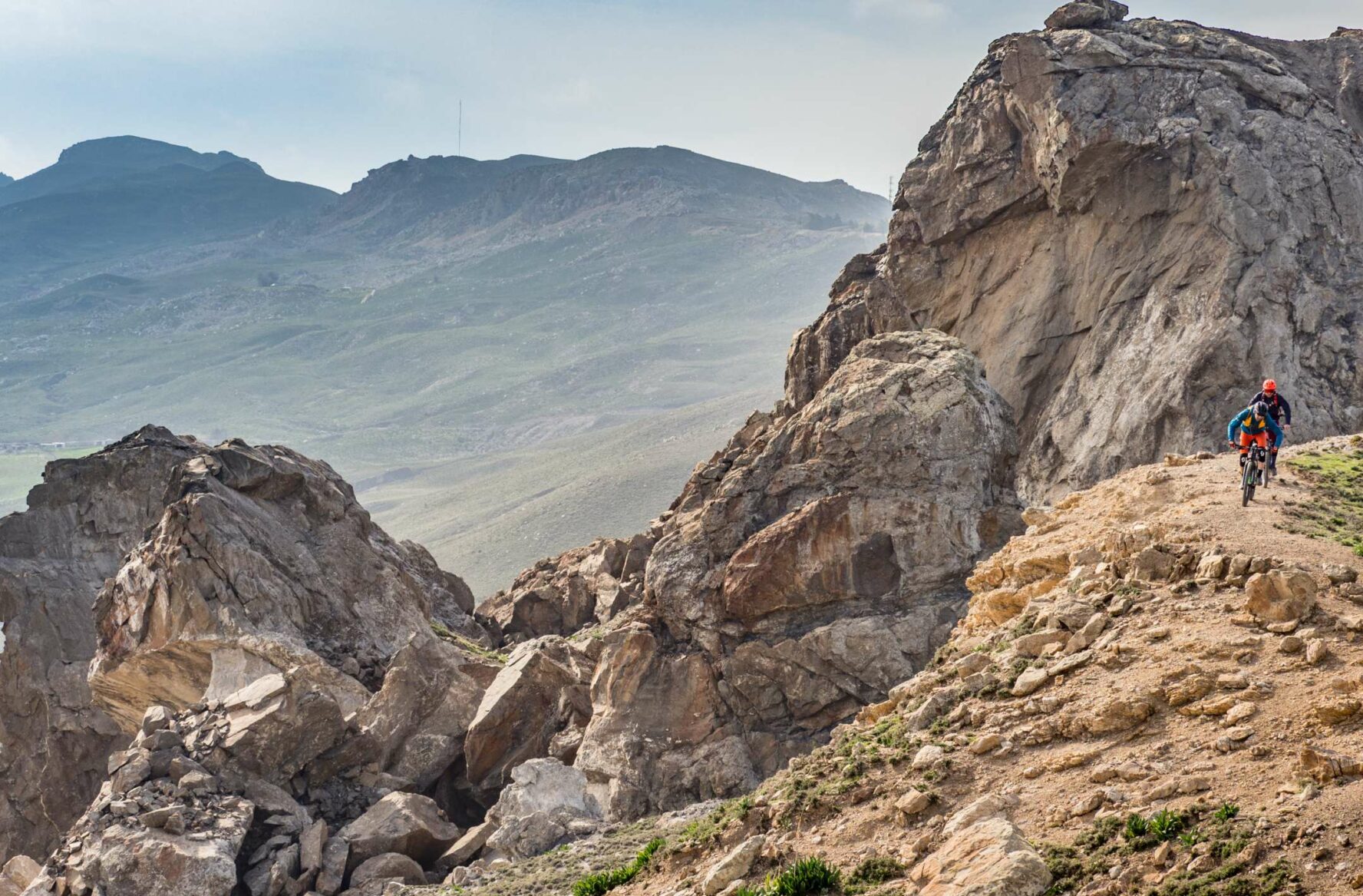 Mountain bikers riding through rugged terrain in the South Greek Aegean.