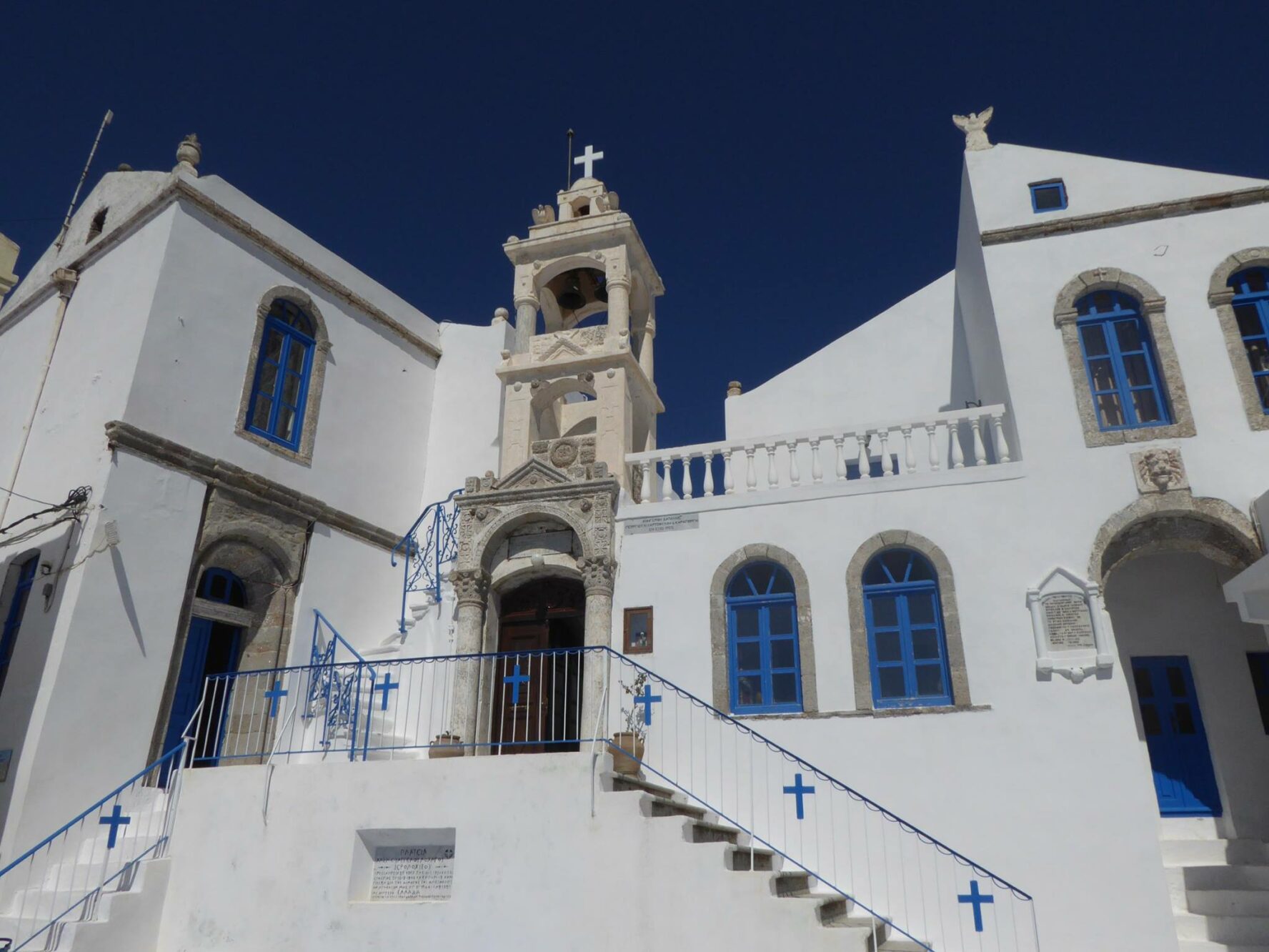 Typical Greek architecture with what-washed facades, classical elements, and blue details.