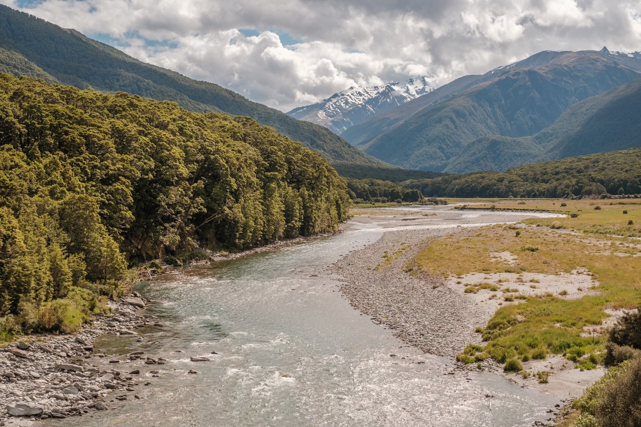 A river in New Zealand with the Southern Alps in the distance, seen while on the Great West Coast cycle trail.