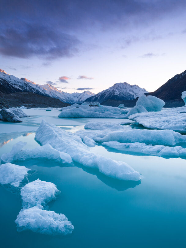 Two cyclers on a trail with mountains in the background
