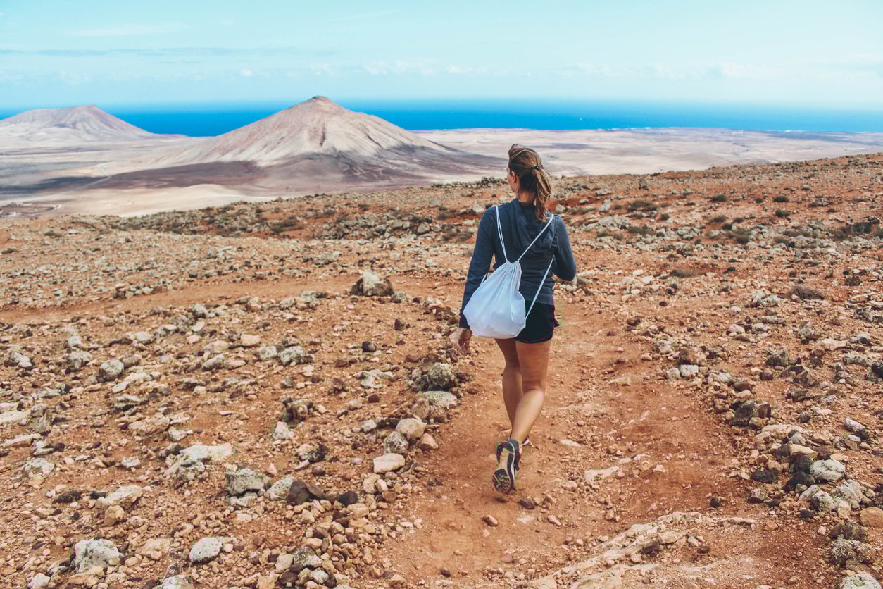 A woman hiking and admiring the Martian landscapes of Fuerteventura’s interior.