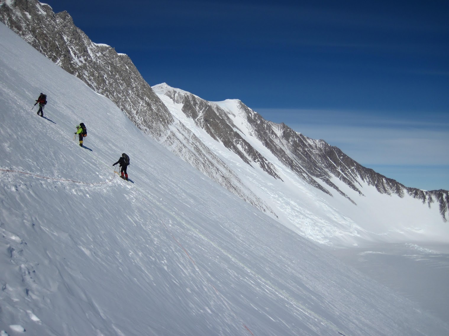Three mountaineers on a steep icy slope near Antarctica’s highest peak—Mt Vinson.