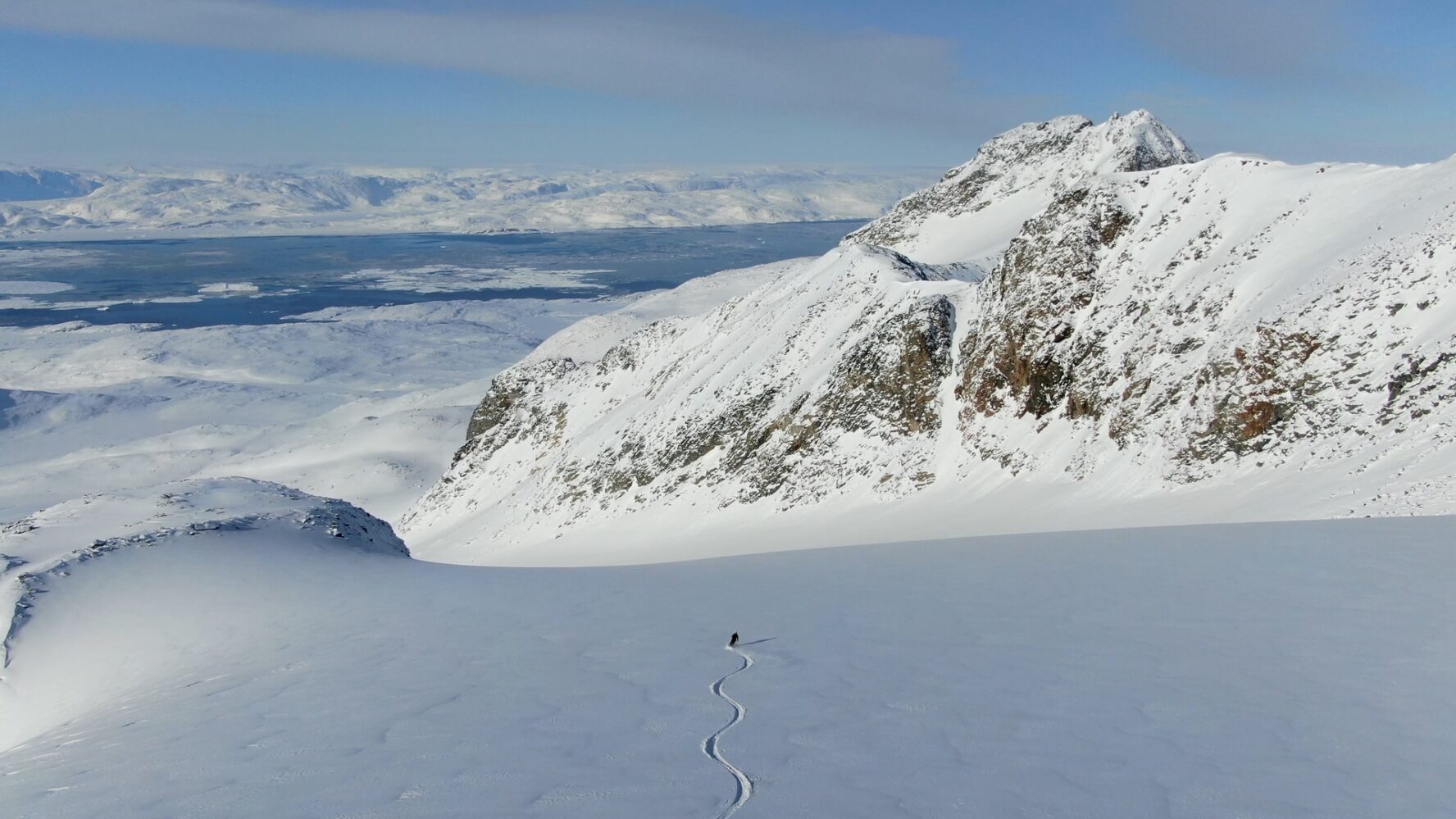 One skier curves in fresh snow in Greenland