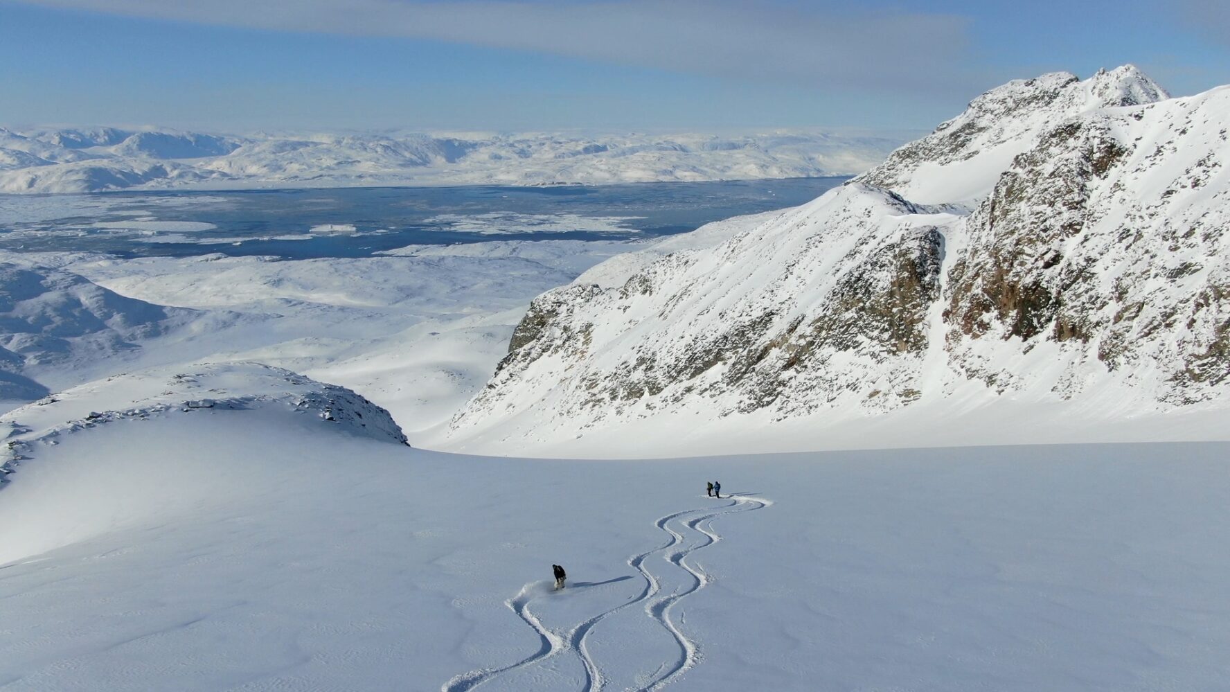 Skier carving lines in fresh snow in Greenland
