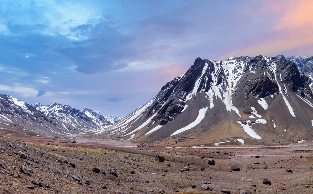A beautiful Andean landscape during sunrise with a high-altitude valley and a snowy mountain.