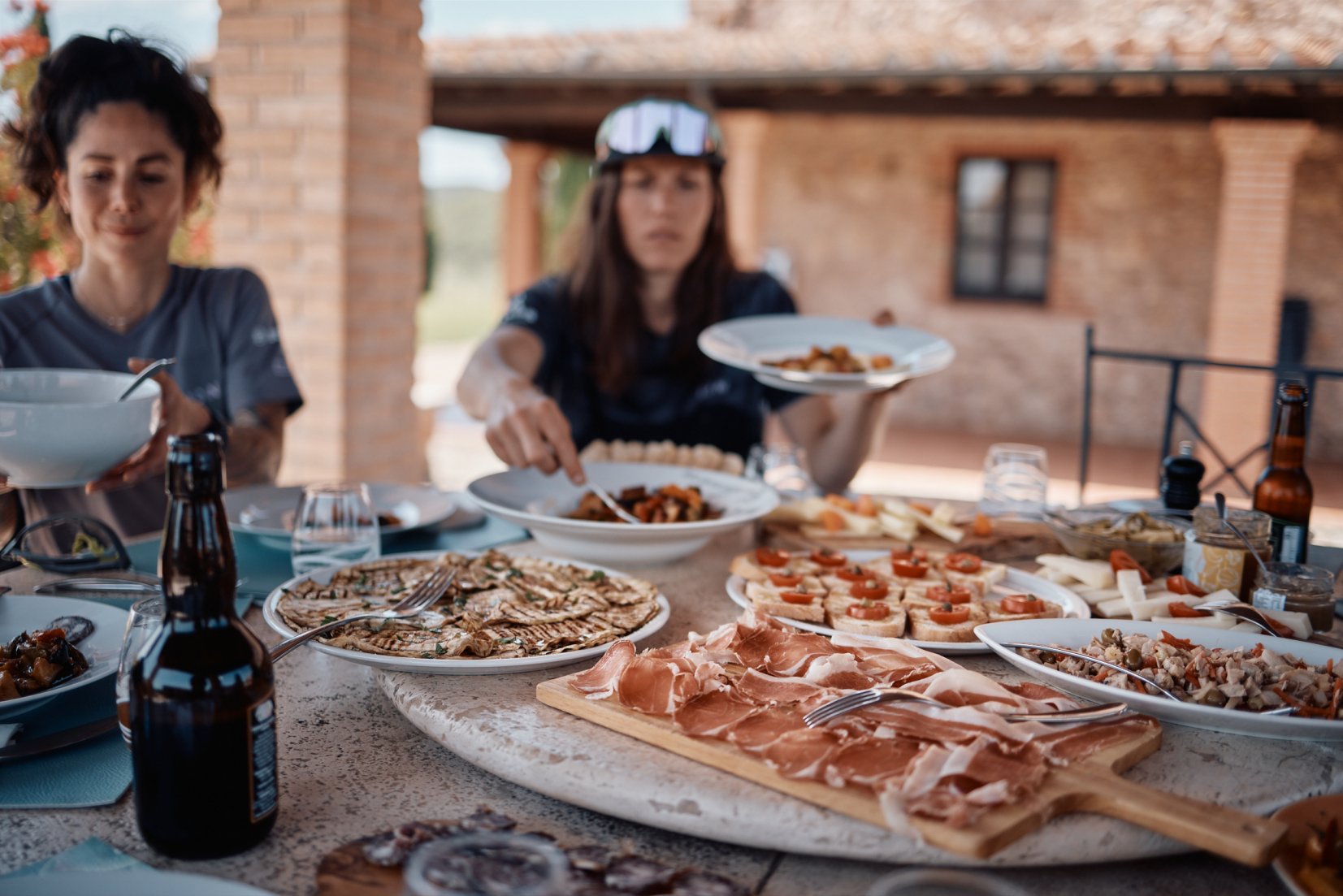 E-mountain bikers enjoying an antipasto with bruschettas and grilled eggplants in Tuscany.