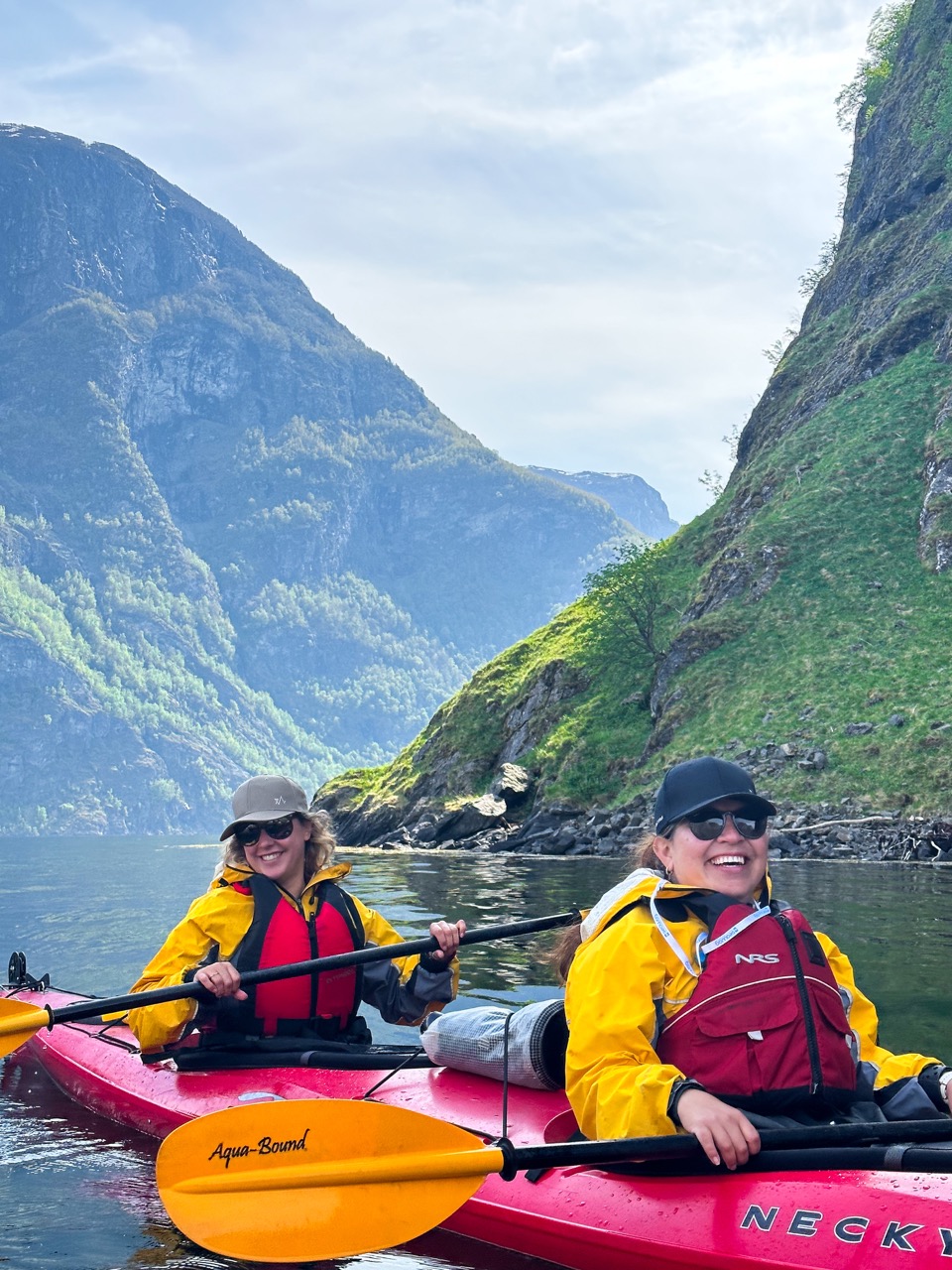 Two happy kayakers and mountains in the background