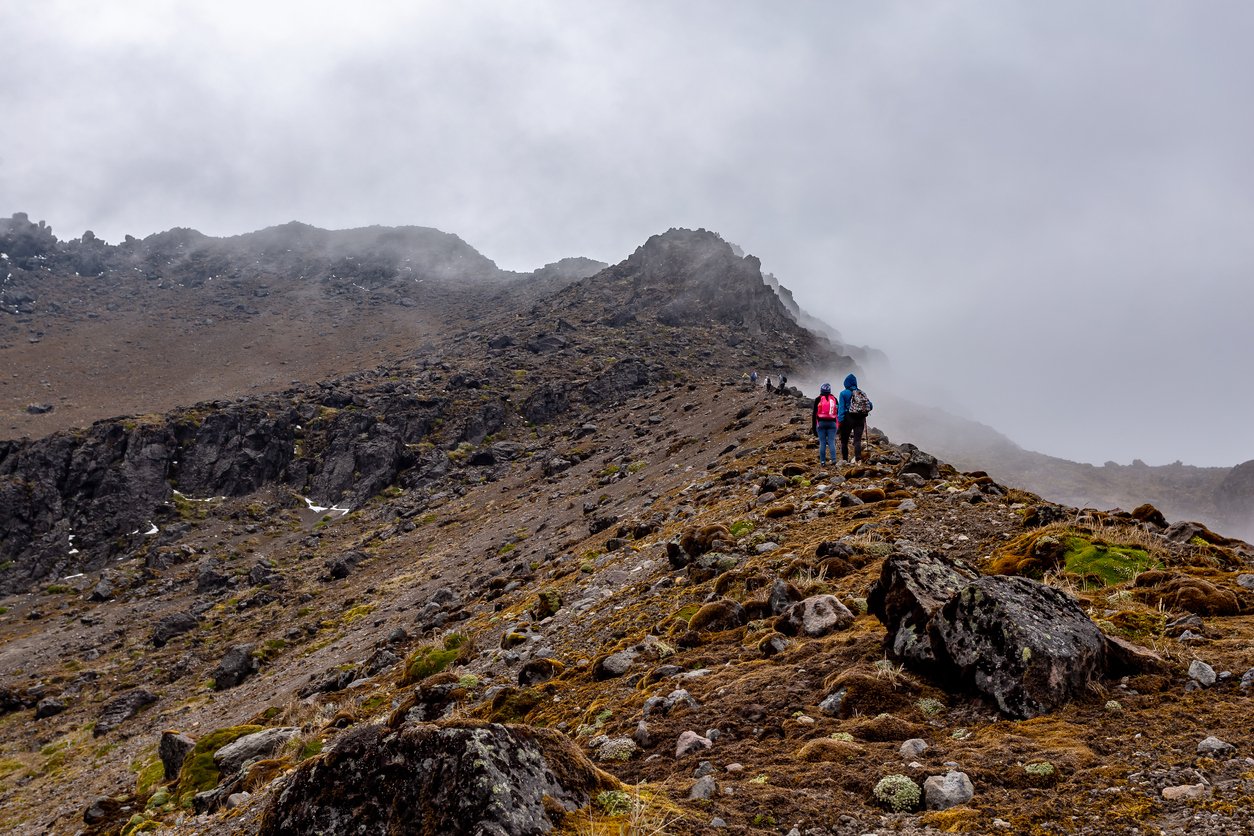 Two mountaineers walking gin the volcanic terrain while climbing one of the Ilinizas, Ecuador.