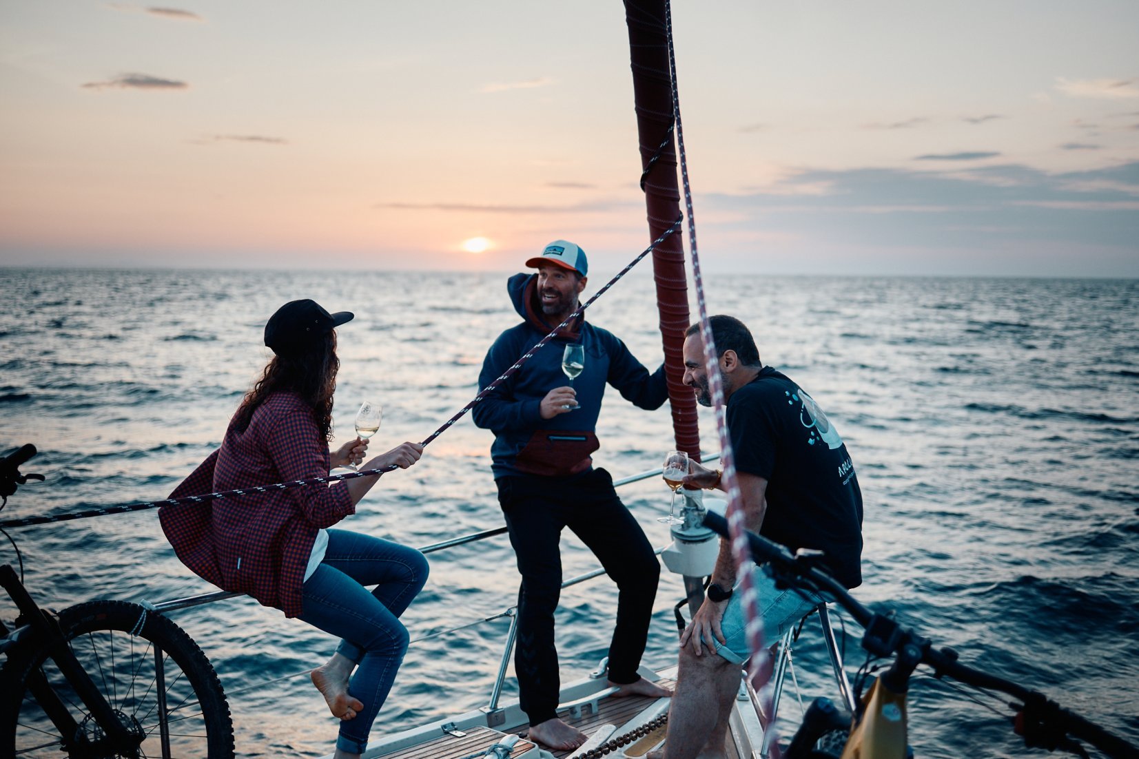 E-mountain bikers enjoying a drink on the deck of the sailboat taking them to the island of Elba.