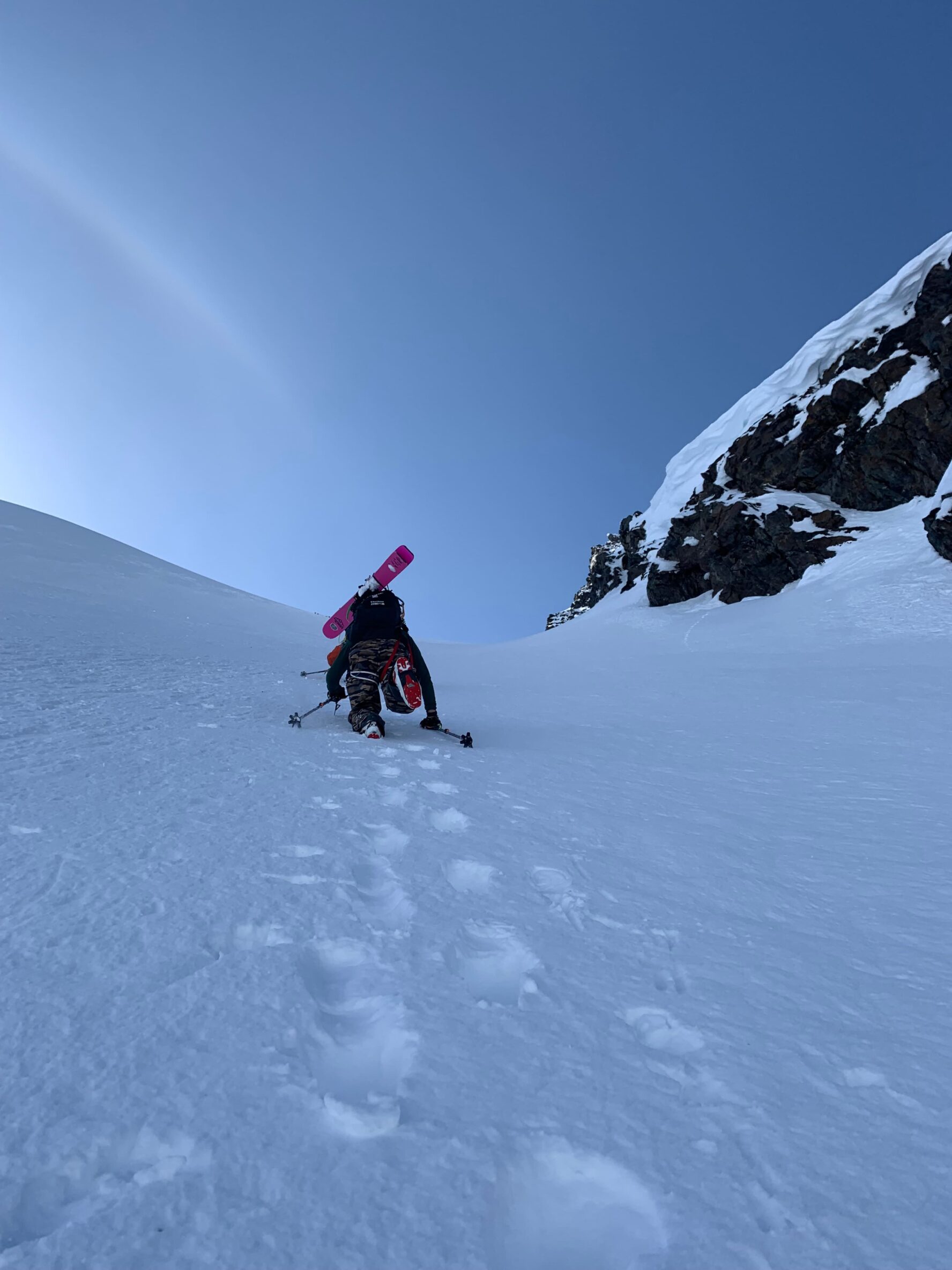 Skier climbing up a steep climb in Alaska