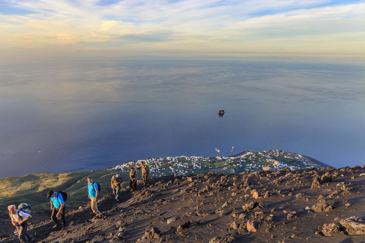 A group of hikers near the rim of the Stromboli volcano, enjoying the incredible views.