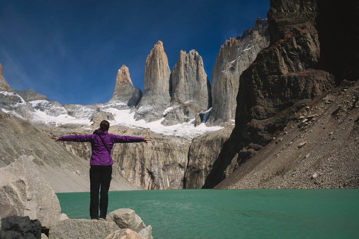A hiker mesmerized by the iconic Torres del Paine during the O Circuit trek.