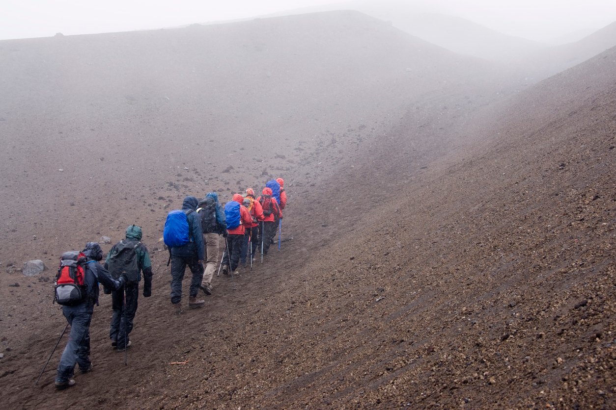 Mountaineers walking in steep volcanic terrain in Ecuador’s Avenue of the Volcanoes.