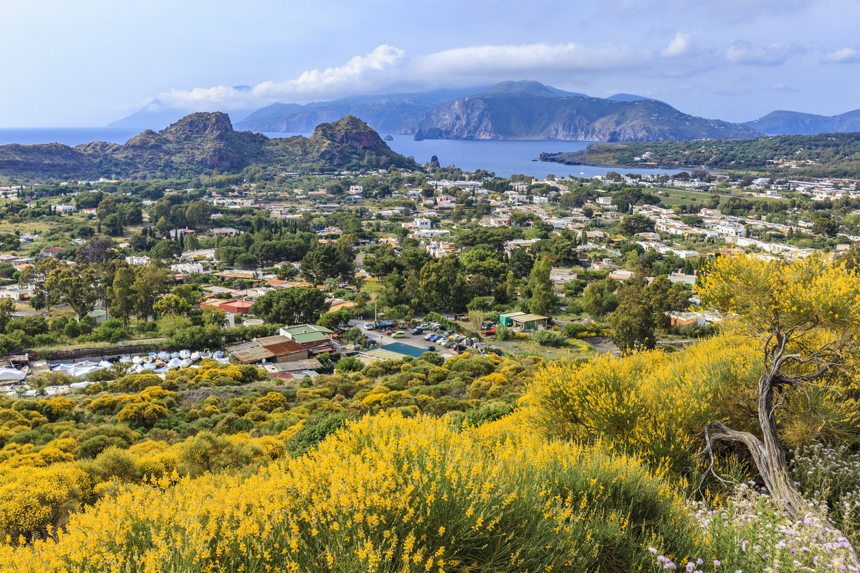 The town on the island of Vulcano seen from a distance with views of the sea and surrounding islands.