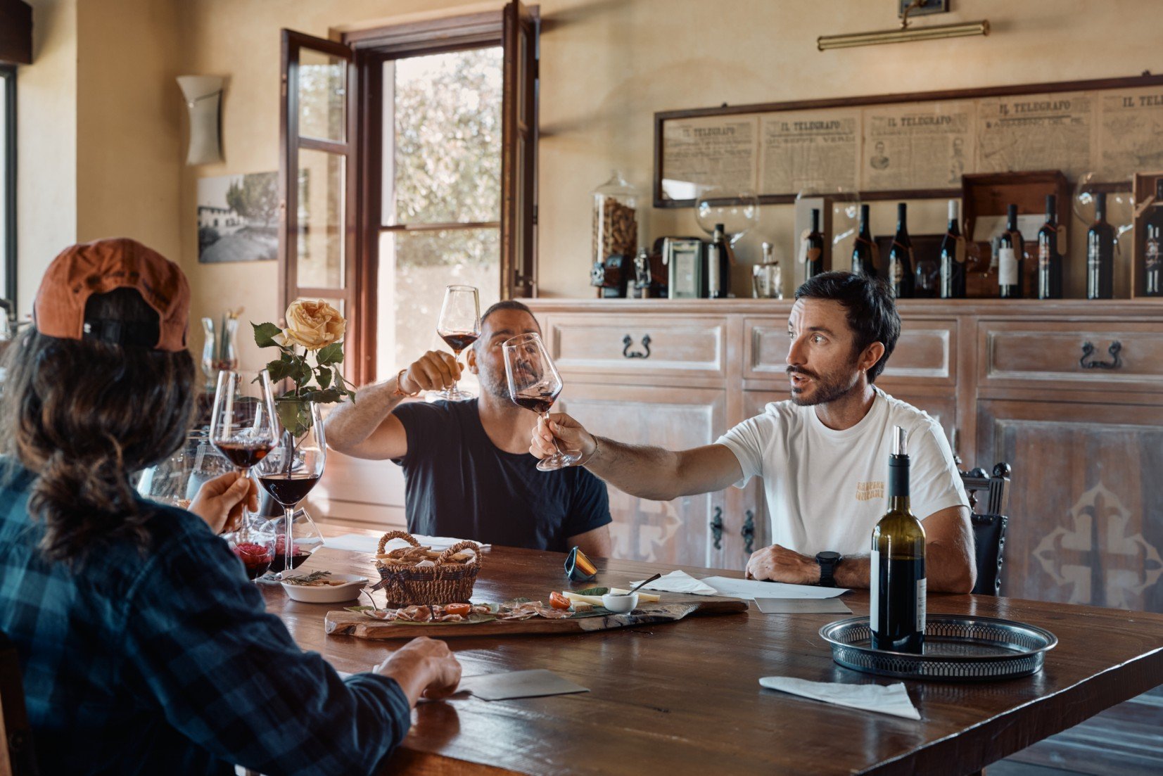 E-mountain bikers enjoying wine tasting in Tuscany in a rustically decorated room.