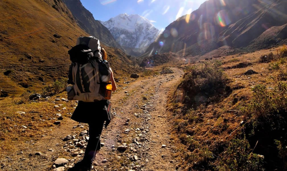 A woman trekker on a trail in the Andes, Salkantay Trek, taking her to Machu Picchu.