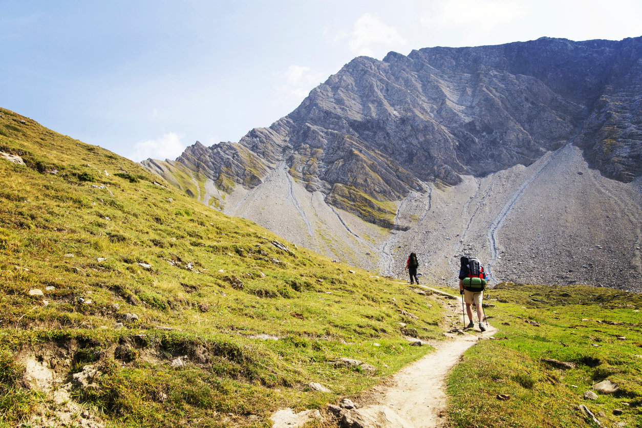 Two backpackers on a hiking trail which is part of the TMB.