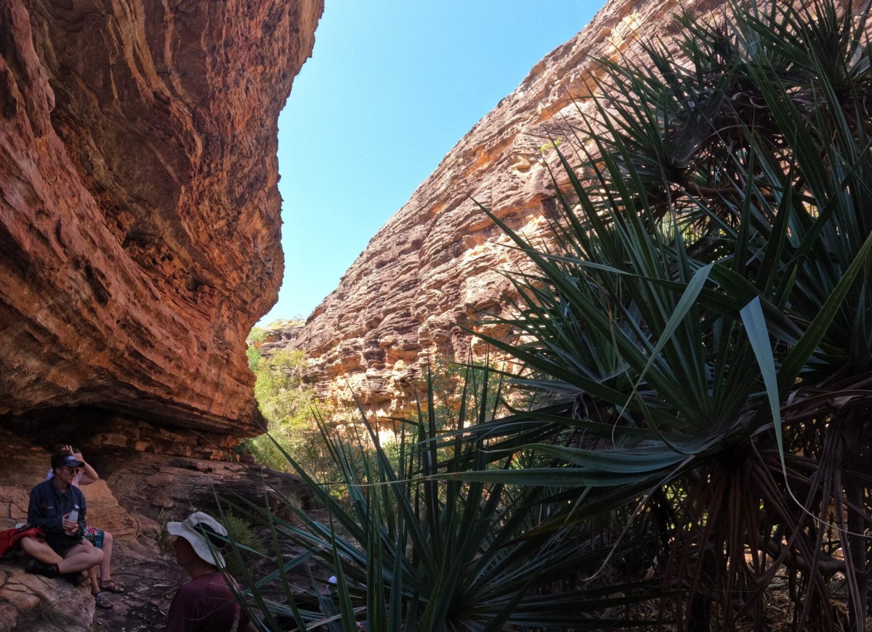 A hiker sitting in shade between to cliffs in Australia.