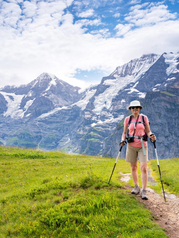 Hikers on a trail beside the Oeschinen lake, Swiss Alps.