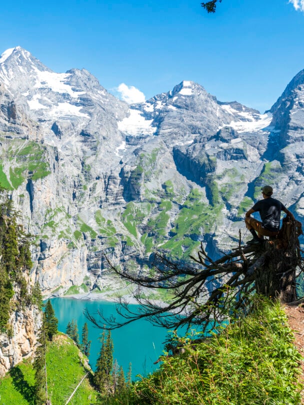 Hikers on a trail beside the Oeschinen lake, Swiss Alps.