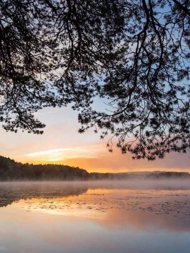 Two hikers crossing a shallow river