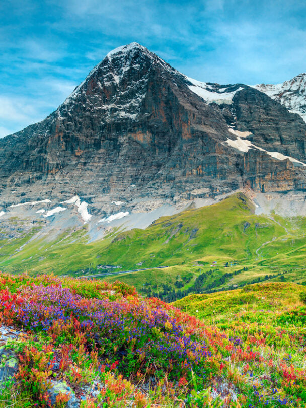 Hikers on a trail beside the Oeschinen lake, Swiss Alps.