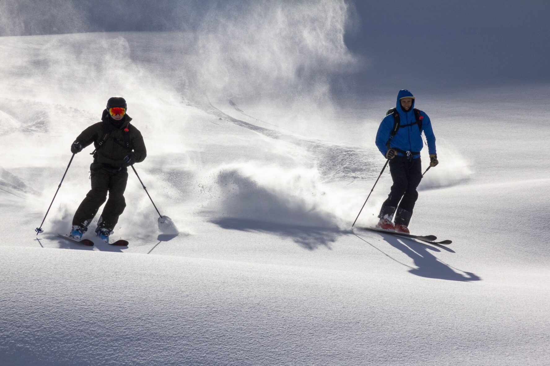 Two skiers on powder in the Swiss Alps