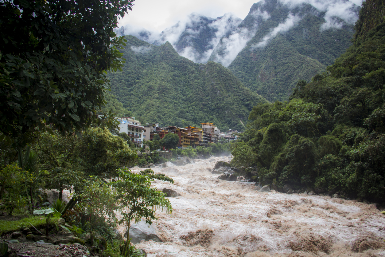 The Peruvian town of Aguas Calientes, surrounded by a cloud forest and soaring, mist-covered hills.