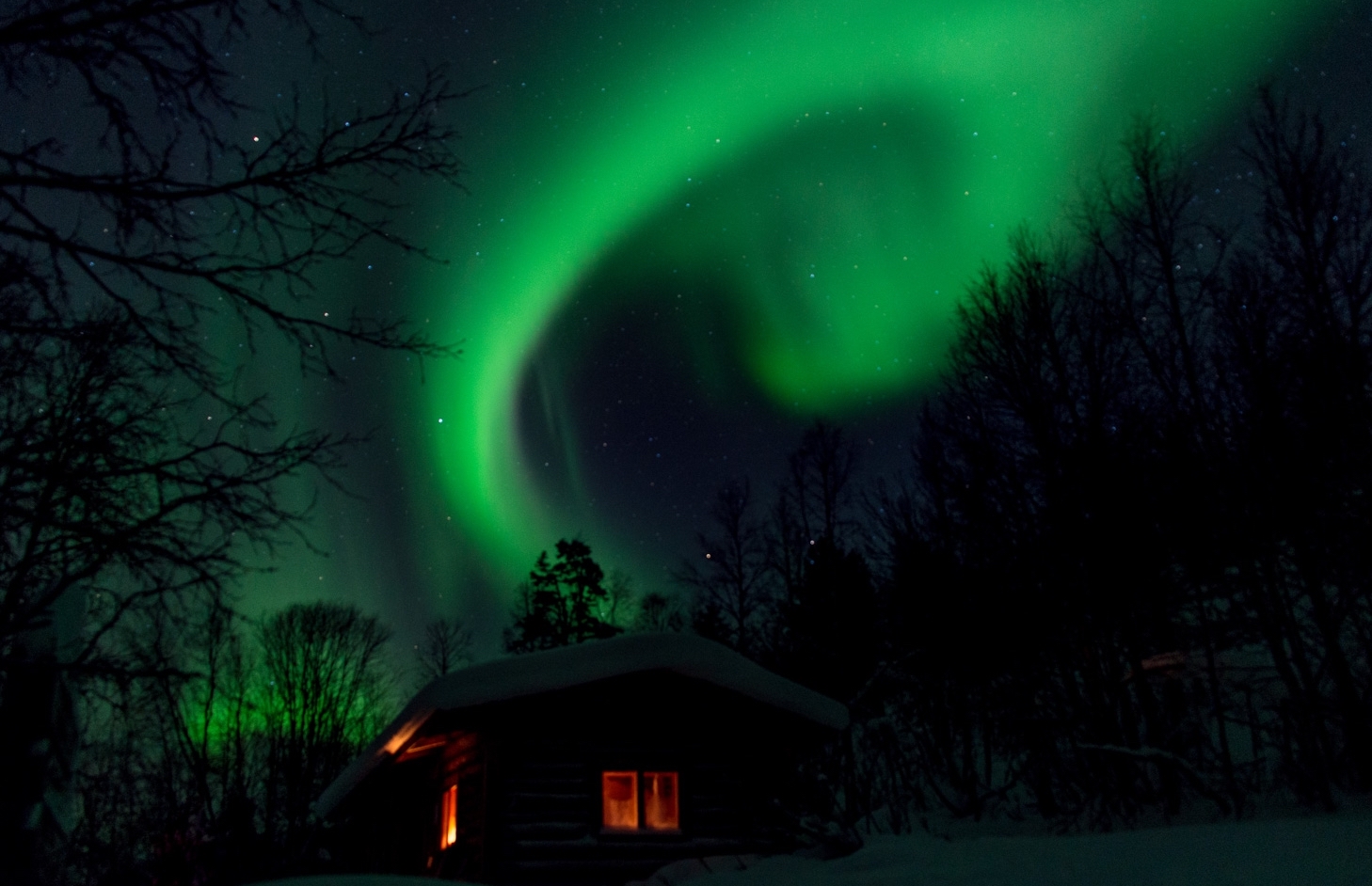 A cabin in Finland with the Northern Lights shining above