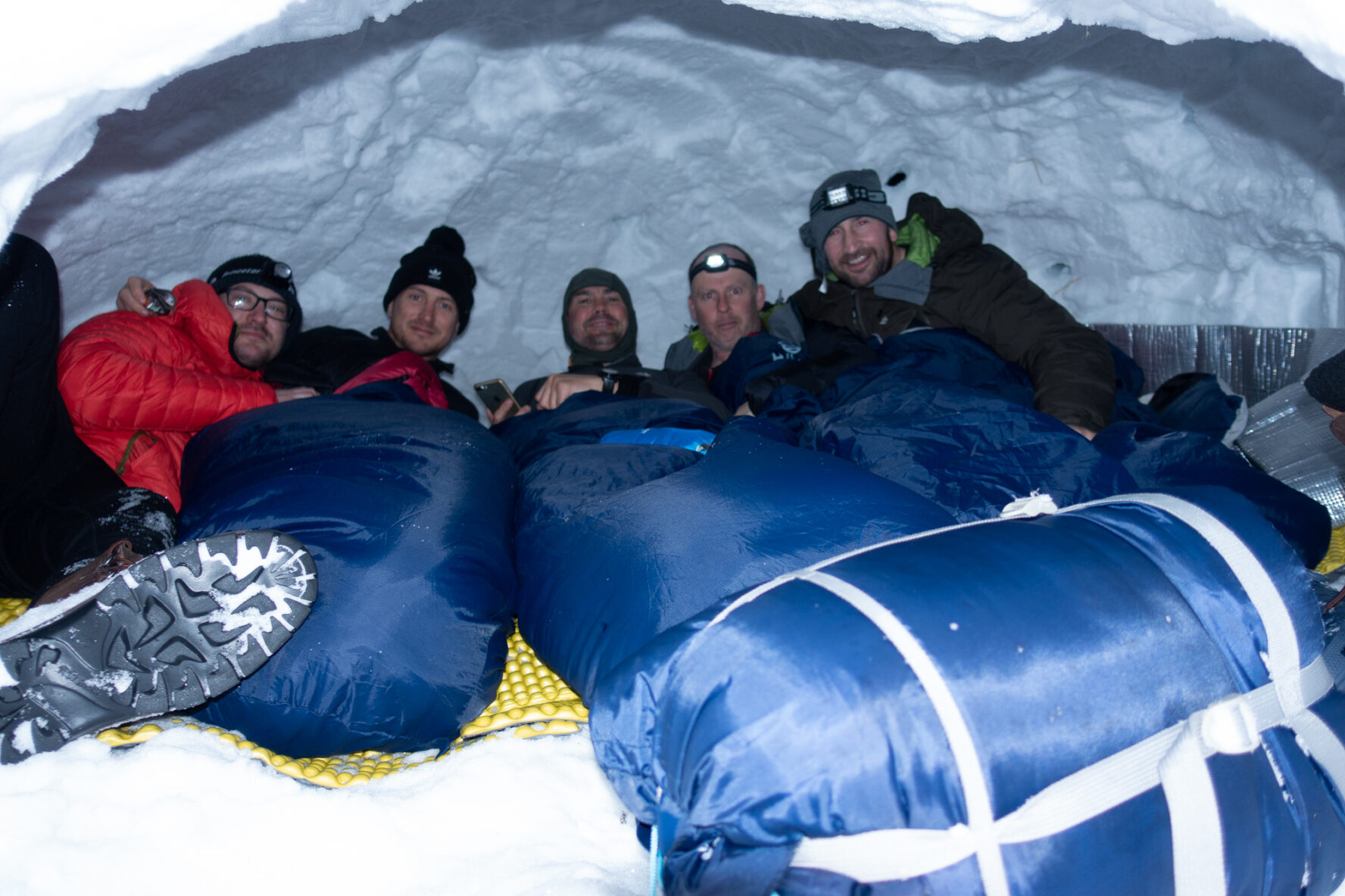 Skiers posing inside the quinzee