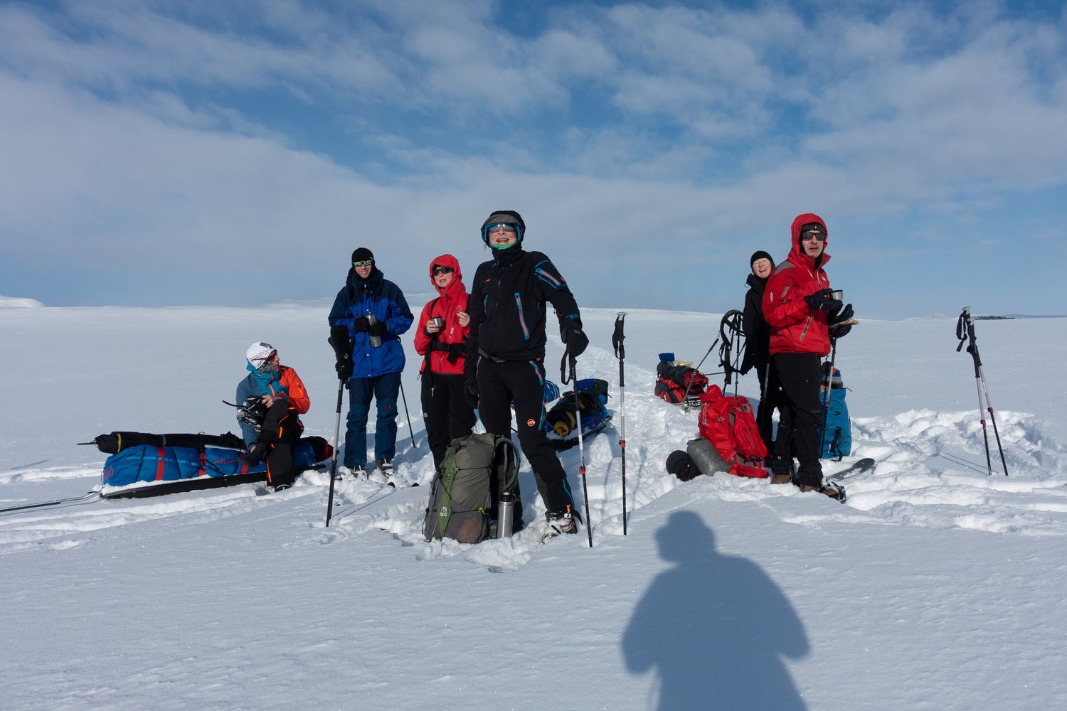 Skiers in Halti posing in front of a snowy landscape.