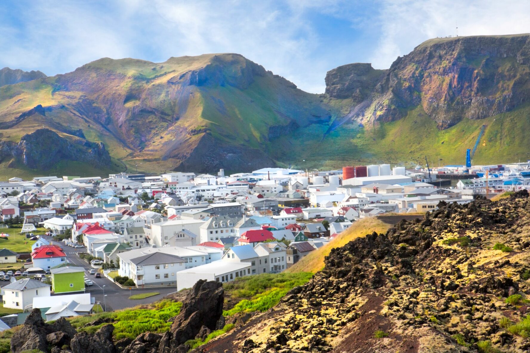 Vedute of the Heimaey town located on the eponymous islands, surrounded by steep green mountains.