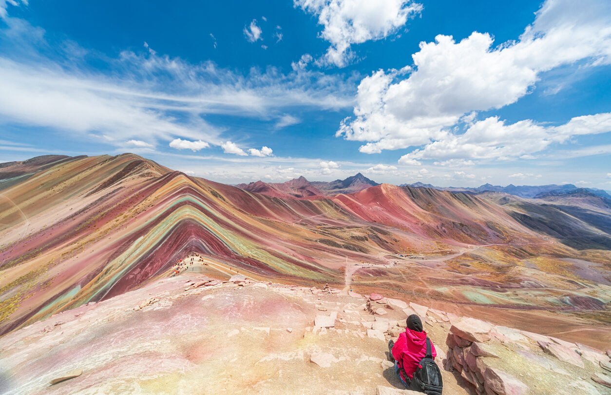 Hiker enjoying the view of Vinicunca, Rainbow Mountain, in Peru.