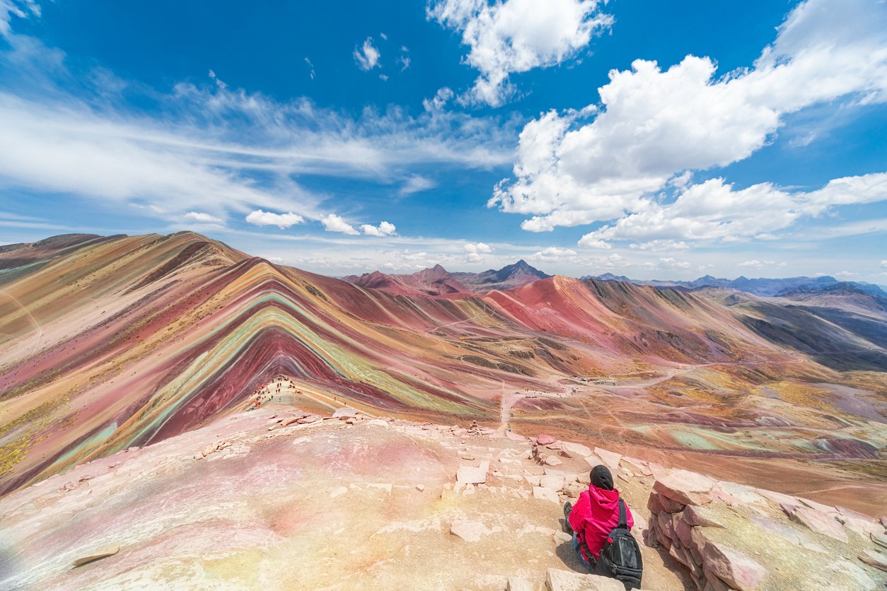 Hiker enjoying the view of Vinicunca, Rainbow Mountain, in Peru.