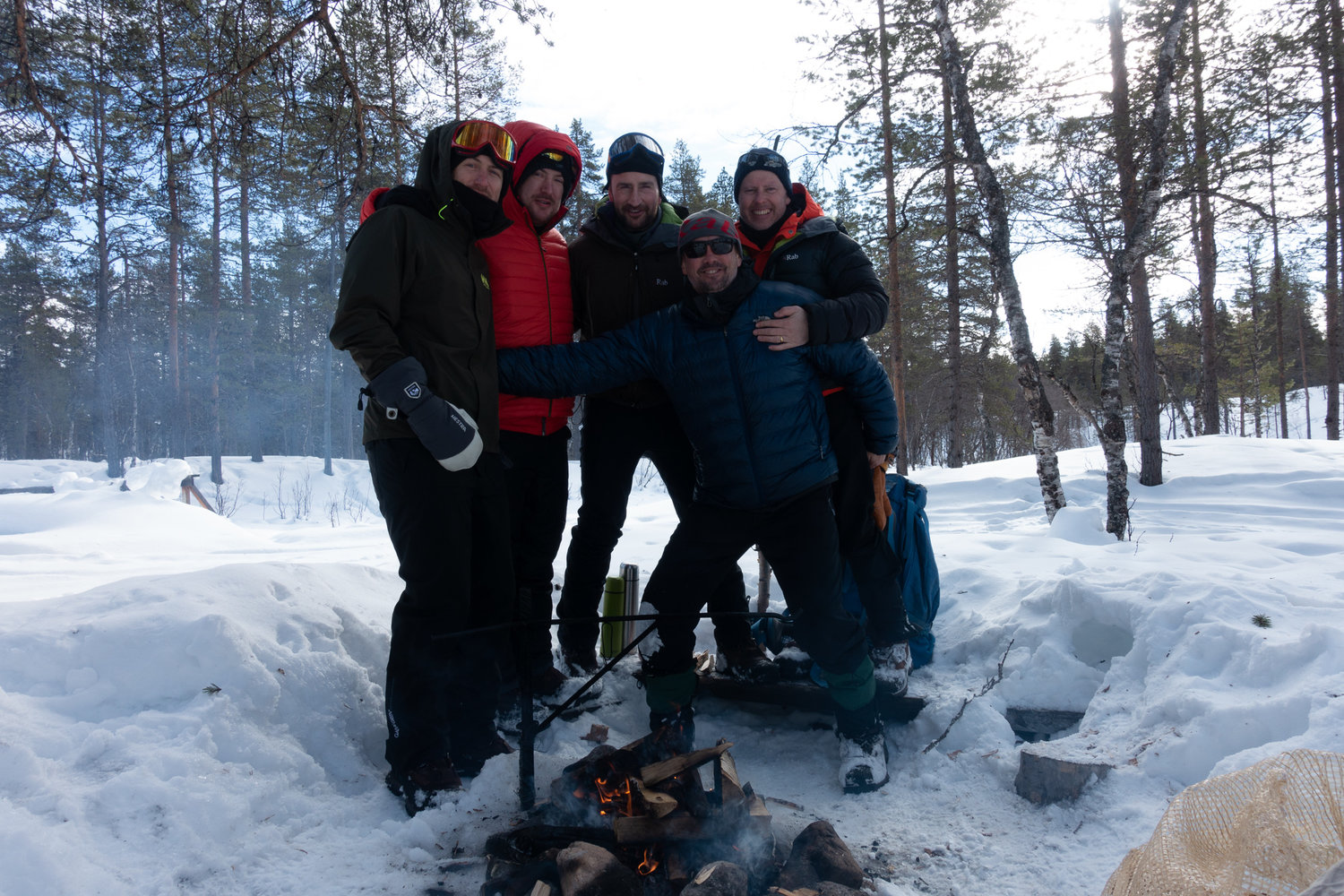 Some ski tourers posing by a fire in Lemmenjoki NP, Finland