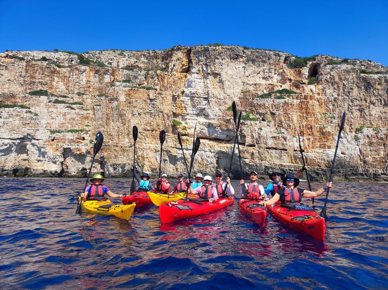 Kayakers posing with their paddles